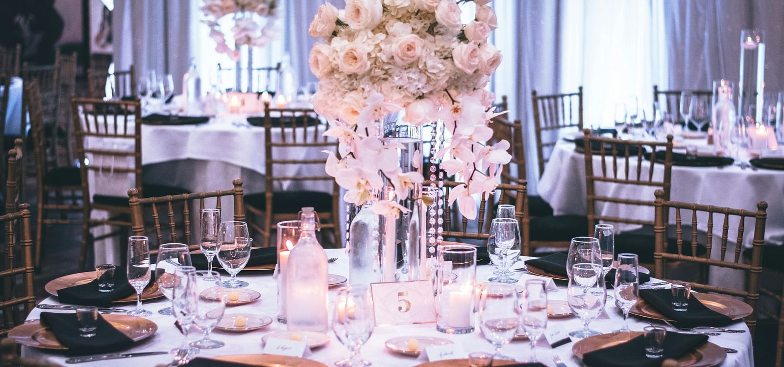 A beautifully decorated table for a special event, featuring a large floral arrangement.